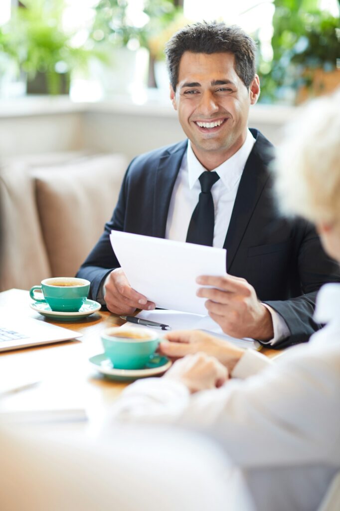Cheerful lawyer talking to client in cafe